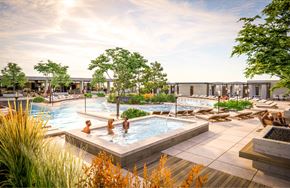 Lehi apartment for rent - A group of people are enjoying a hot tub in a large outdoor pool area.
