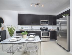 Miami apartment for rent - A modern kitchen with a dining table set for two.