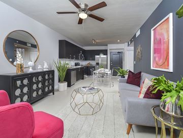 Miami apartment for rent - A living room with a red chair and a grey couch.