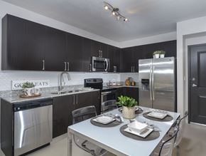 Miami apartment for rent - A modern kitchen with a dining table set for two.