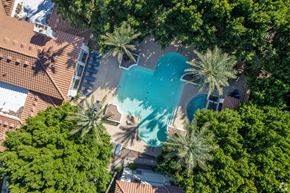 Glendale apartment for rent - A swimming pool surrounded by trees and a building.