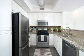 San Diego apartment for rent - a kitchen with stainless steel fridge, dishwasher, stove and sink with white cabinets