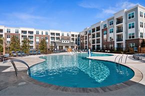 Matthews apartment for rent - A large swimming pool in front of apartment buildings.