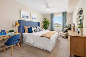 Folsom apartment for rent - A bedroom with a large bed, a desk with a chair, and a dresser with a mirror.