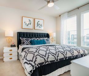 Dallas apartment for rent - A bedroom with a large bed and two framed pictures on the wall.