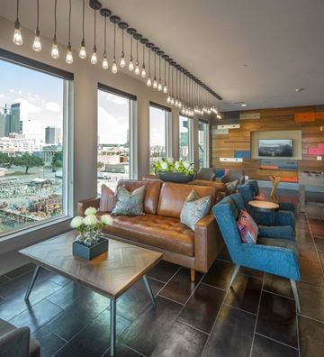 Dallas apartment for rent - A living room with a brown leather couch and a wooden coffee table.