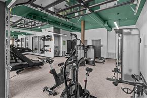 Dallas apartment for rent - A gym with a variety of equipment including treadmills, weights, and exercise bikes.