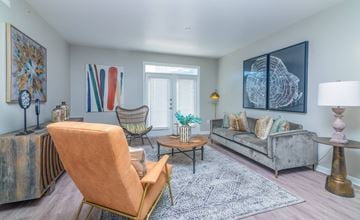 Dallas apartment for rent - A living room with a chair, a sofa, a table, and a painting on the wall.