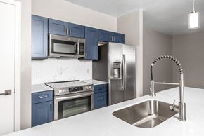 Dallas apartment for rent - A kitchen with blue cabinets and stainless steel appliances.