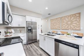 Pembroke Pines apartment for rent - A modern kitchen with white cabinets and stainless steel appliances.