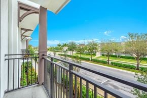 Pembroke Pines apartment for rent - A balcony with a metal railing overlooks a street with trees and houses.