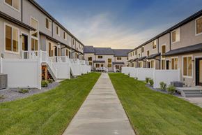 Herriman apartment for rent - A long concrete walkway leads between a row of houses.