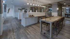 Miami apartment for rent - A modern kitchen with a long table and chairs.