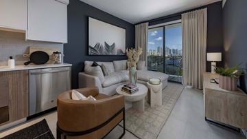 Miami apartment for rent - A modern living room with a brown leather chair and a large window overlooking the city.