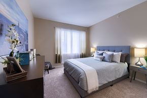 Lakewood apartment for rent - A bedroom with a large bed and a painting on the wall.