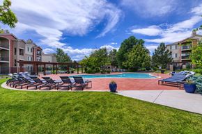 Lakewood apartment for rent - A swimming pool surrounded by lawn chairs and trees.