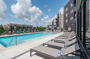 Kansas City apartment for rent - A pool with sun loungers and a building in the background.