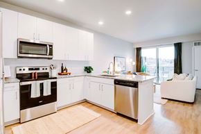Kansas City apartment for rent - A modern kitchen with white cabinets and stainless steel appliances.