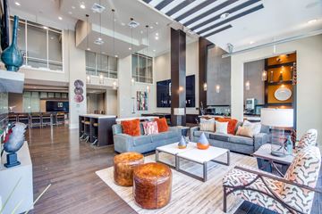 Spring apartment for rent - A modern living room with a grey couch and a wooden floor.