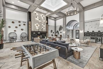San Antonio apartment for rent - A foosball table is in the middle of a living room with a couch and a fireplace.