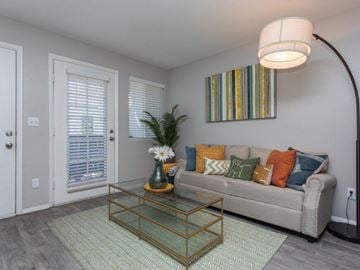 Salt Lake City apartment for rent - A living room with a glass coffee table and a striped picture on the wall.