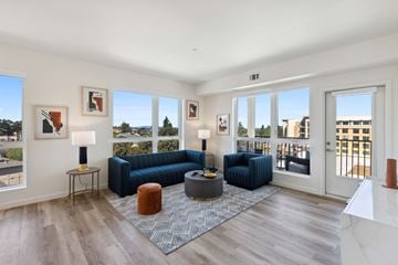 Hayward apartment for rent - A living room with a blue couch and a grey ottoman.