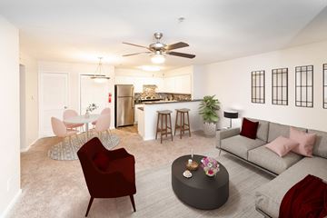Houston apartment for rent - A living room with a red chair and a grey couch.