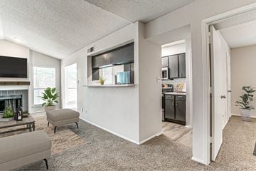 Lewisville apartment for rent - A living room with a grey couch and a television on the wall.