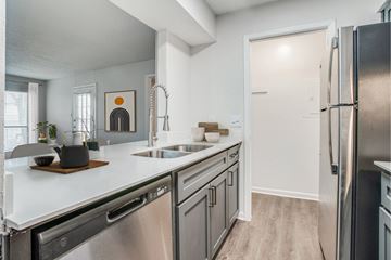 Mckinney apartment for rent - A modern kitchen with a stainless steel refrigerator and a wooden cutting board on the counter.