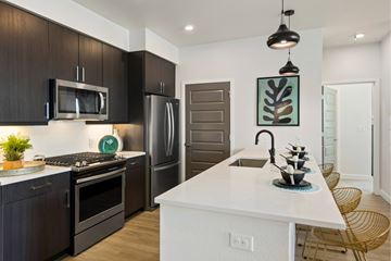 Denver apartment for rent - A modern kitchen with dark brown cabinets and a white island.