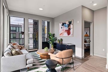 Seattle apartment for rent - A modern living room with a large painting on the wall and a striped rug on the floor.