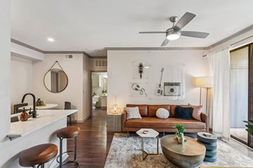 Austin apartment for rent - A modern living room with a brown leather couch and a wooden coffee table.