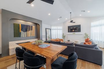 Houston apartment for rent - A modern living room with a wooden dining table and grey sofa.