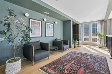Sleepy Hollow apartment for rent - A living room with a grey couch and a red patterned rug.