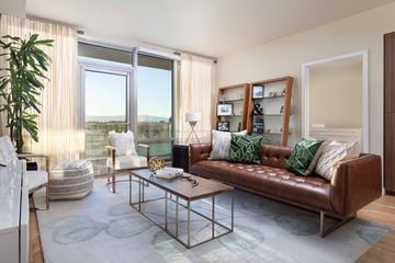 San Jose apartment for rent - A living room with a brown leather couch and a glass coffee table.