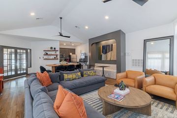 Houston townhouse for rent - A living room with a grey couch and orange pillows.