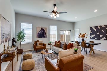 Fort Worth apartment for rent - A living room with a brown leather couch and a ceiling fan.