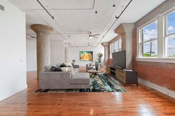 Dallas apartment for rent - A living room with a grey couch and a rug.
