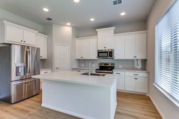 Rockwall apartment for rent - A modern kitchen with white cabinets and stainless steel appliances.