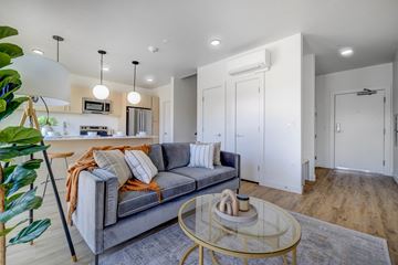 South Salt Lake townhouse for rent - A living room with a grey couch and a glass coffee table.