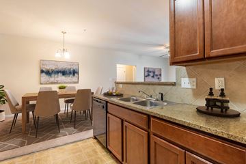 Fayetteville apartment for rent - A kitchen with brown cabinets and a painting hanging above the table.
