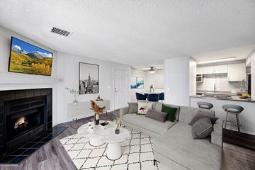Littleton apartment for rent - A living room with a fireplace and a painting of a mountain scene on the wall.