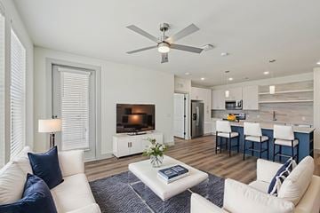 Garland apartment for rent - A living room with a white couch and a ceiling fan.