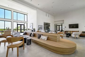Rosenberg apartment for rent - A modern living room with a curved wooden sofa and multiple chairs.