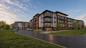 Fort Worth apartment for rent - A modern apartment complex with a curved driveway in front.