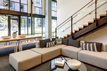 Portland apartment for rent - A modern living room with a glass coffee table and a staircase.