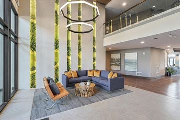 Denver apartment for rent - A modern living room with a large sofa and a coffee table.