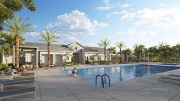 Menifee apartment for rent - A swimming pool surrounded by palm trees and a building in the background.