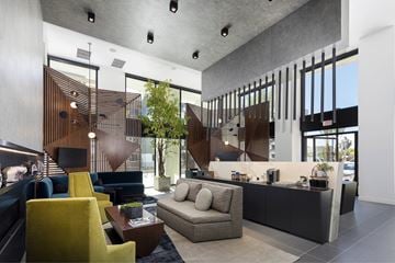 Anaheim apartment for rent - A modern living room with a yellow chair and a grey sofa.