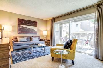San Jose apartment for rent - A living room with a yellow chair and a grey couch.